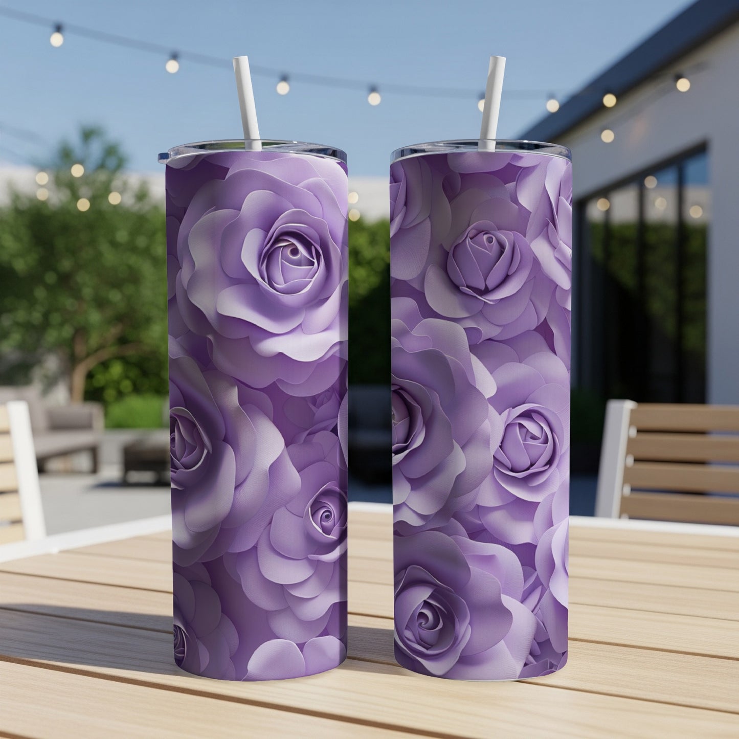 Two tall purple rose pattern tumblers with straws on a wooden table.