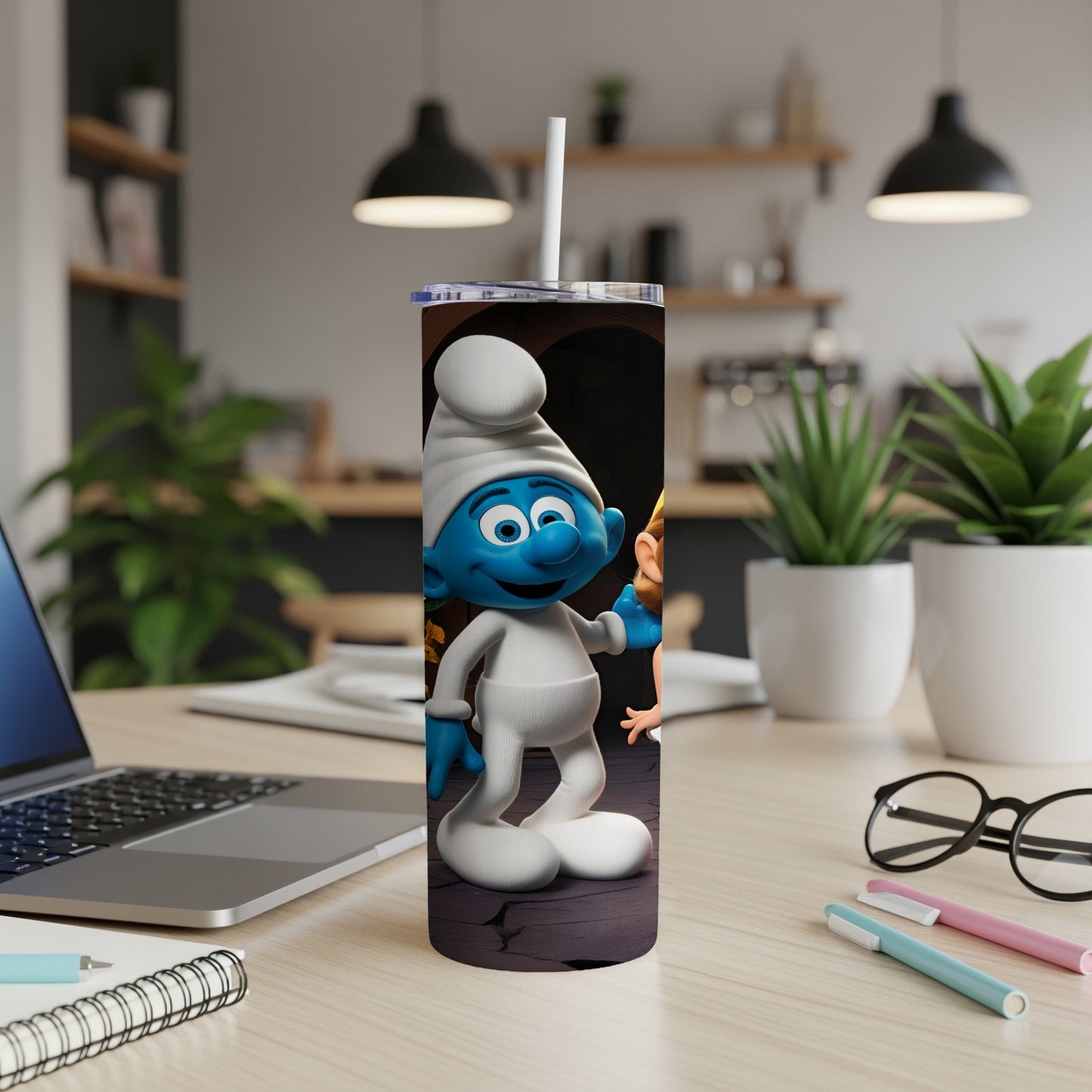 Smurf character on a white tumbler with a straw, on a desk.
