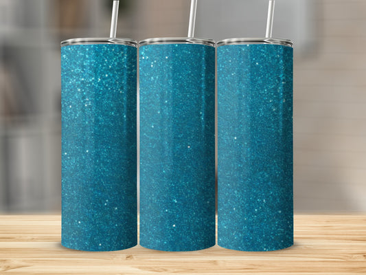 Three blue glitter tumblers with straws on a wooden surface.