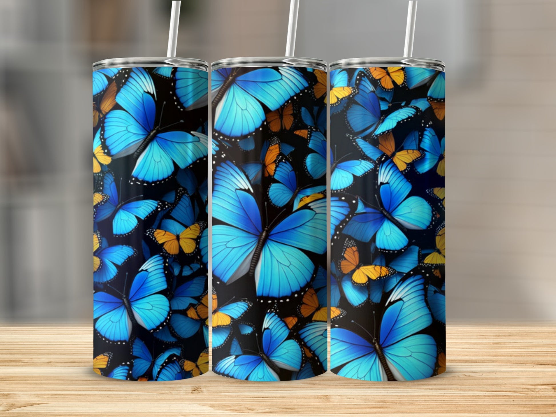 Triptych of tumblers decorated with a vibrant blue and orange butterfly pattern.