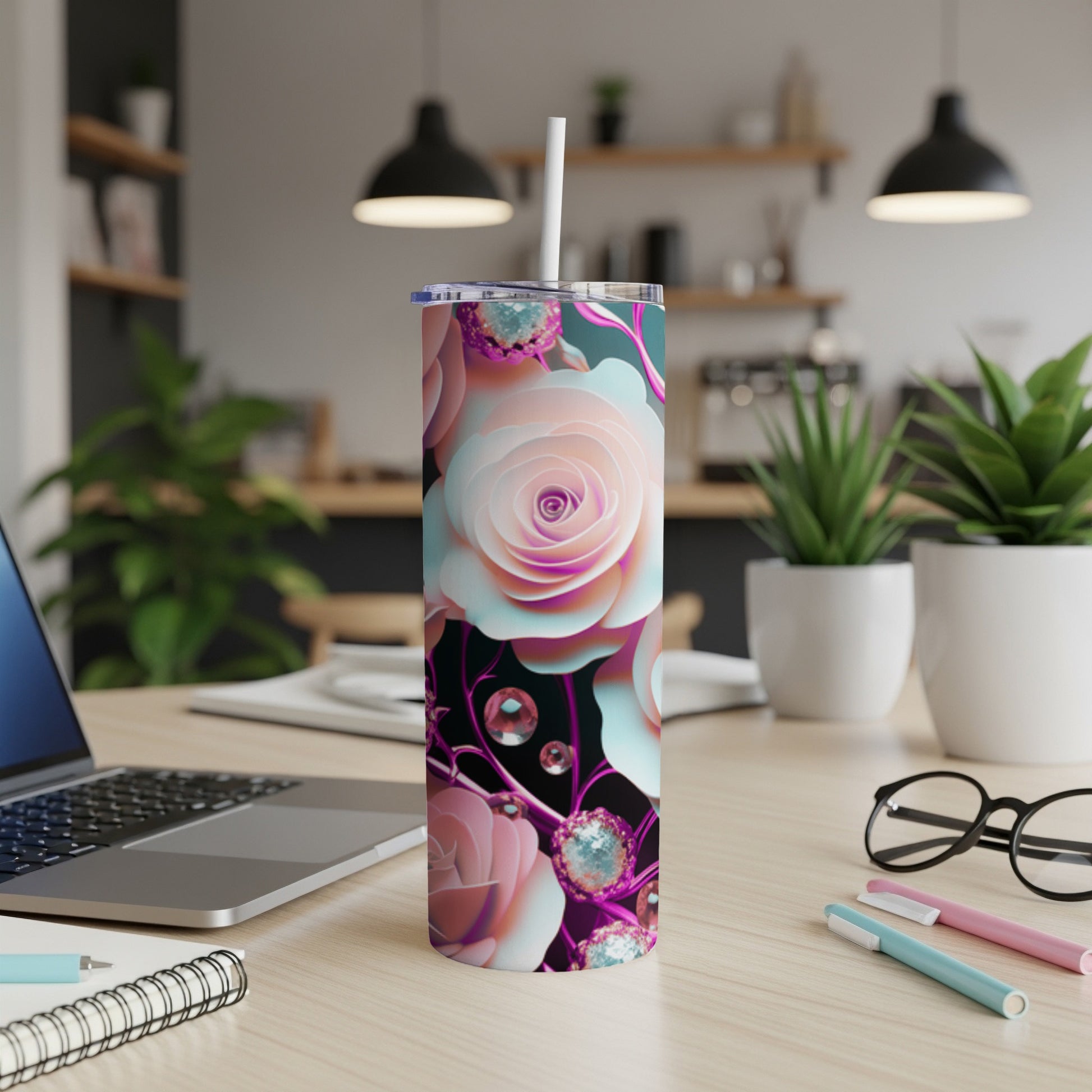 Pink and white floral patterned tumbler with straw on a desk.