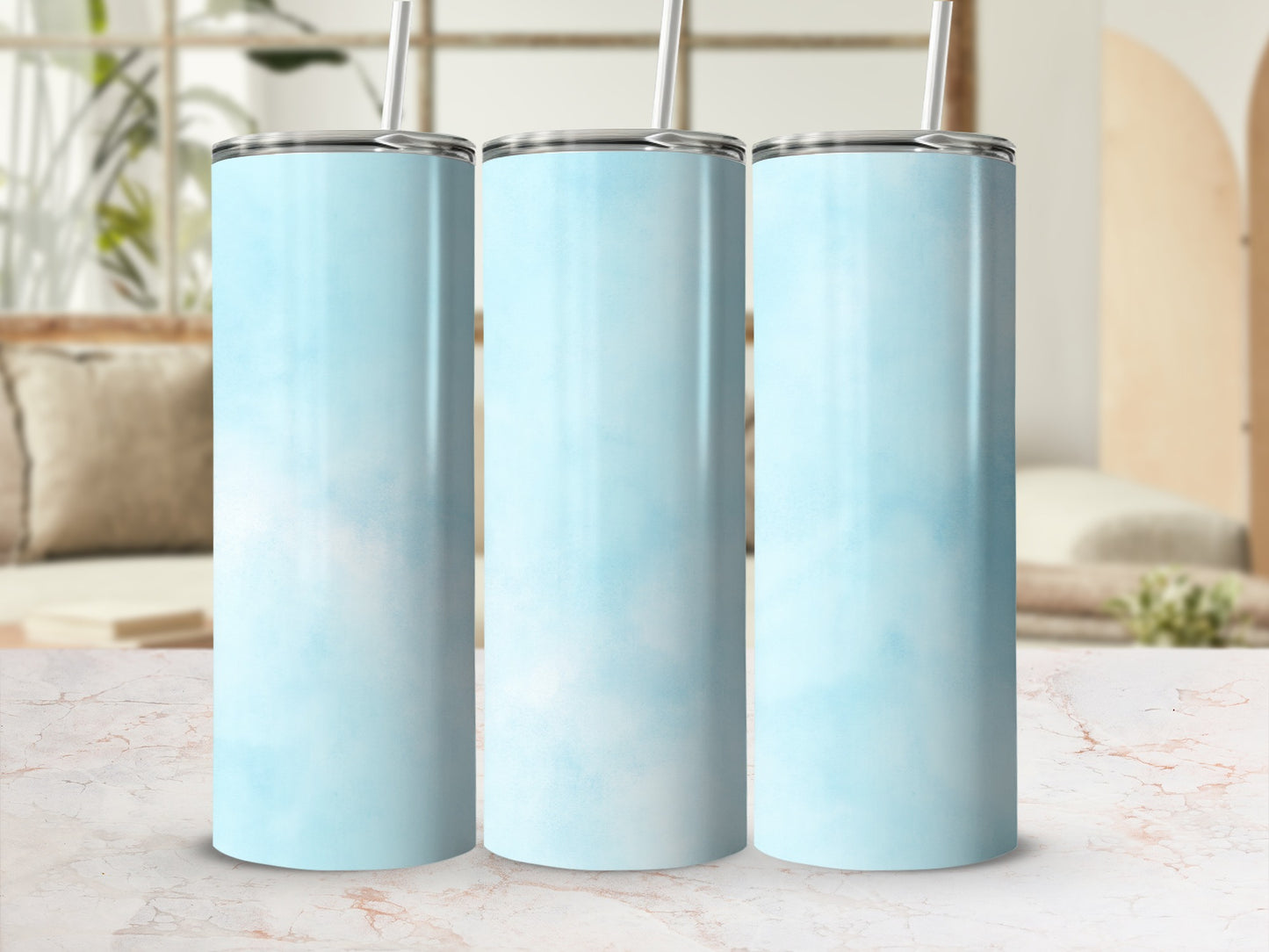 Three light blue ombre stainless steel tumblers with straws.