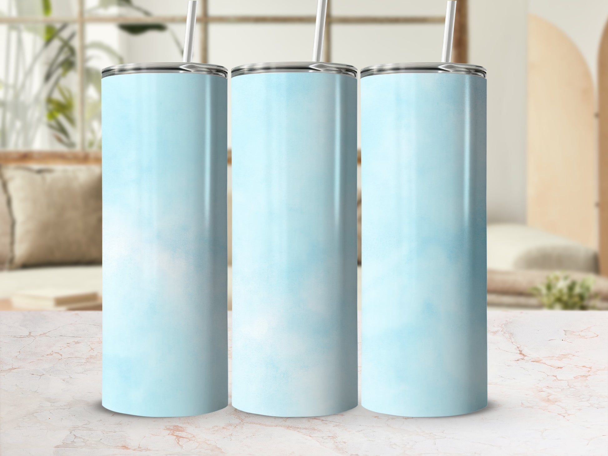 Three light blue ombre stainless steel tumblers with straws.