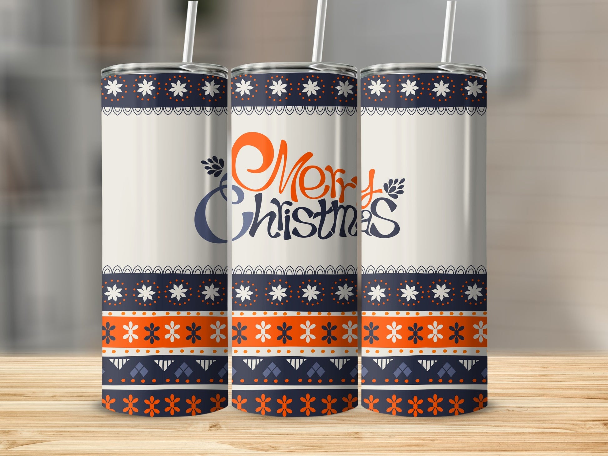 Three tumblers with a blue, orange, and white geometric Christmas design.