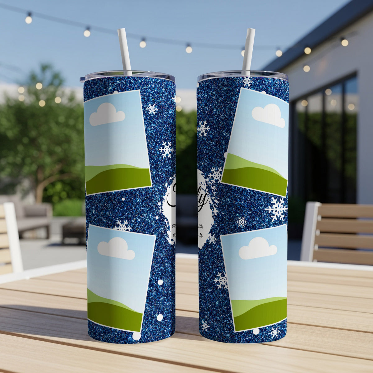 Two glittery blue tumblers with a sky and hills design, featuring snowflakes.