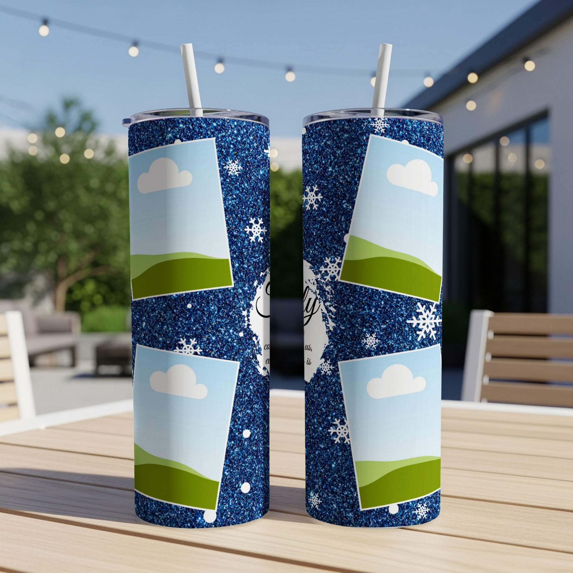 Two glittery blue tumblers with a sky and hills design, featuring snowflakes.