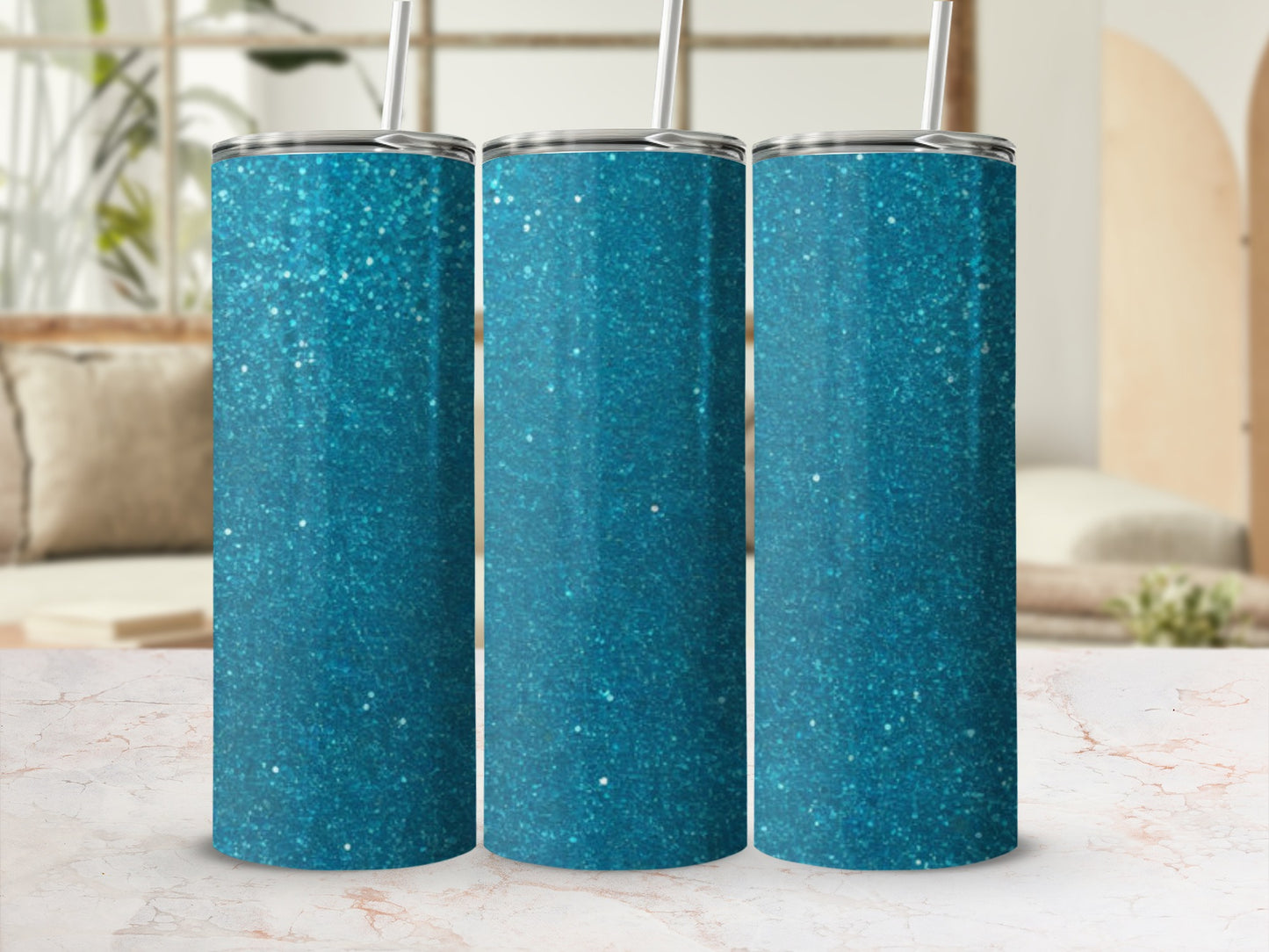 Three teal glitter tumblers with straws, displayed on a marble countertop.