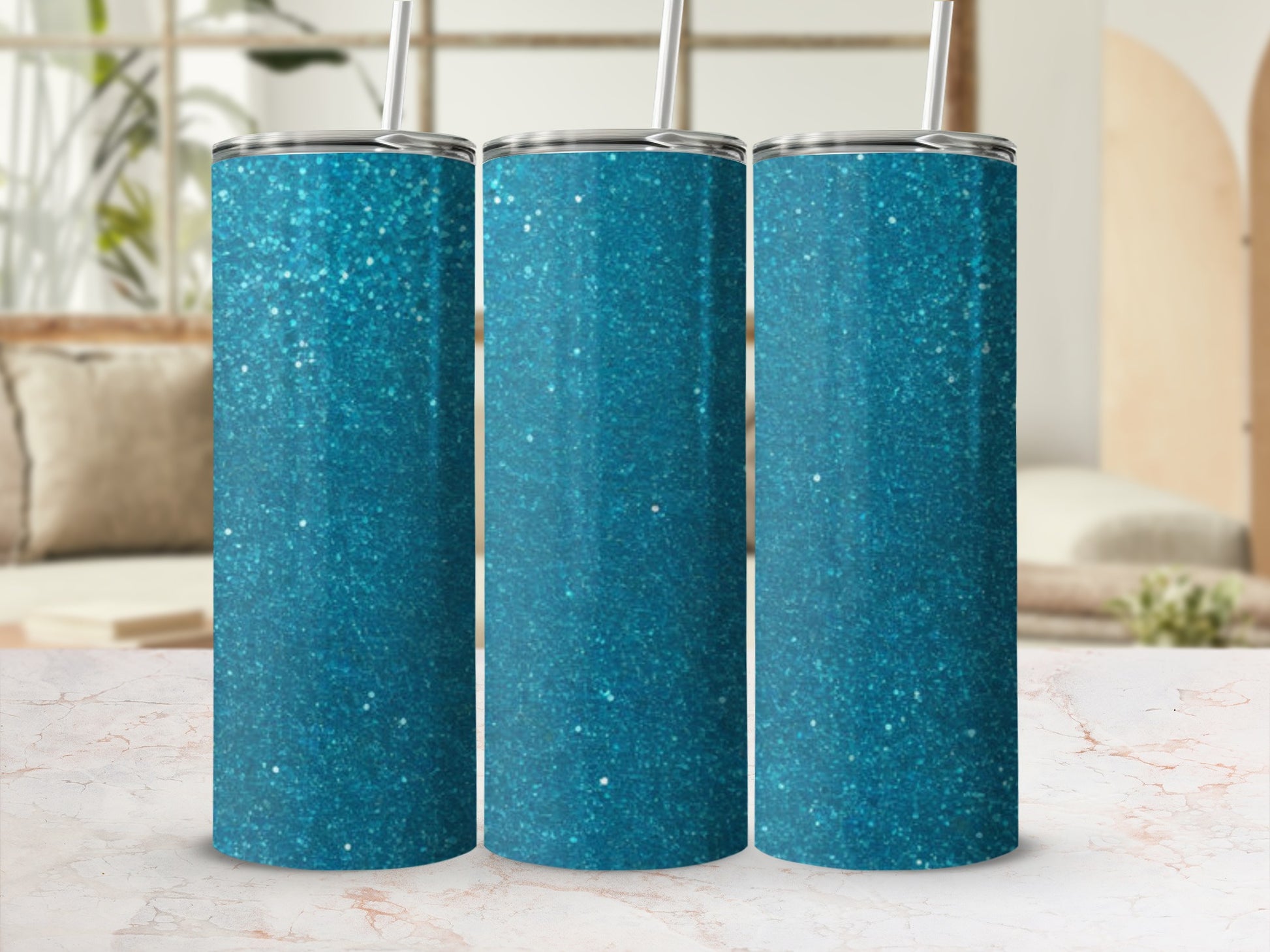 Three teal glitter tumblers with straws, displayed on a marble countertop.