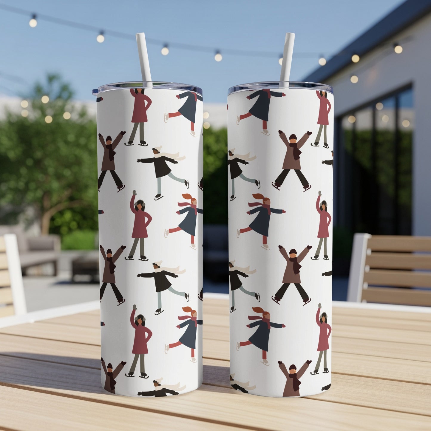 Two tumblers with repeating pattern of ice skaters on a table.