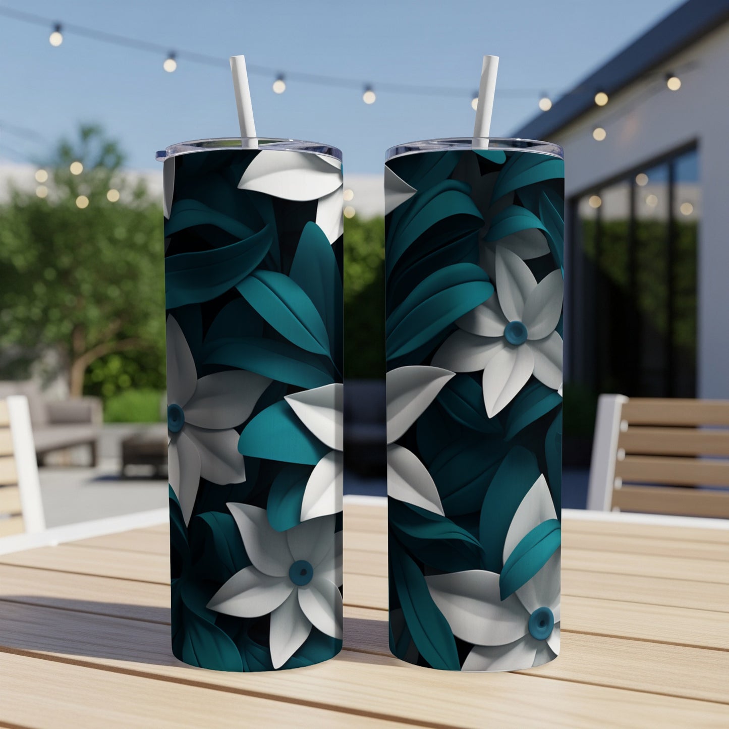Two tumblers with teal and white floral pattern on a wooden table.