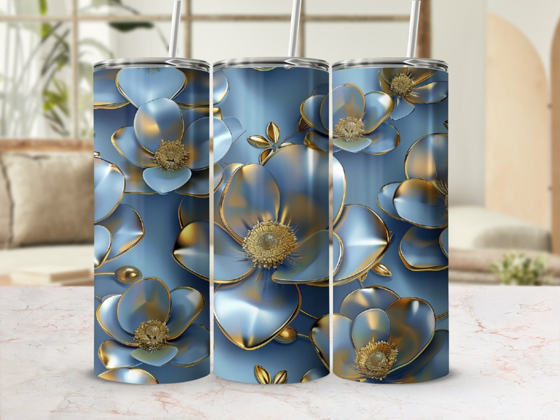 Three blue floral tumblers with gold accents, displayed on a marbled surface.