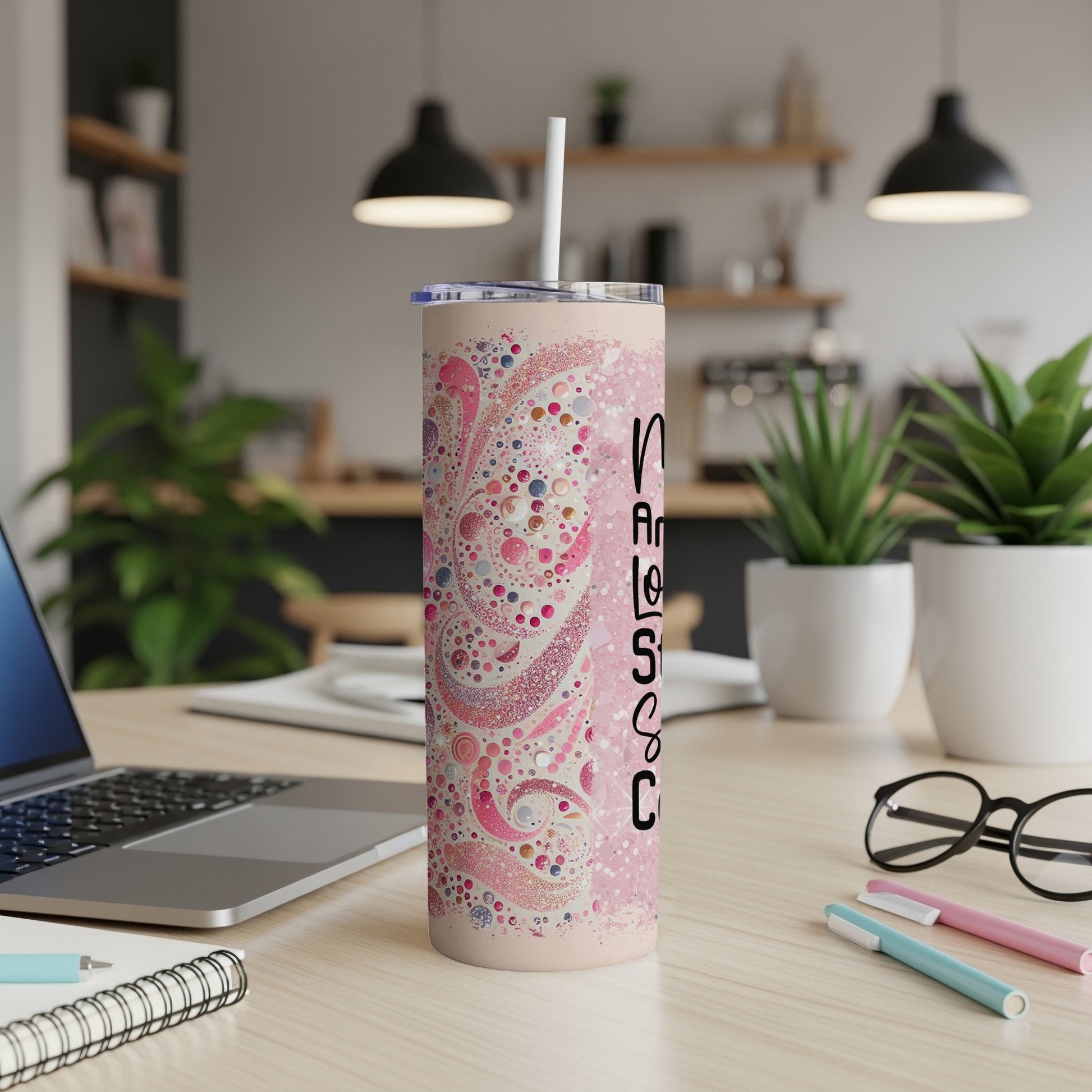 Pink speckled tumbler with "Nurse Life" text on a desk.
