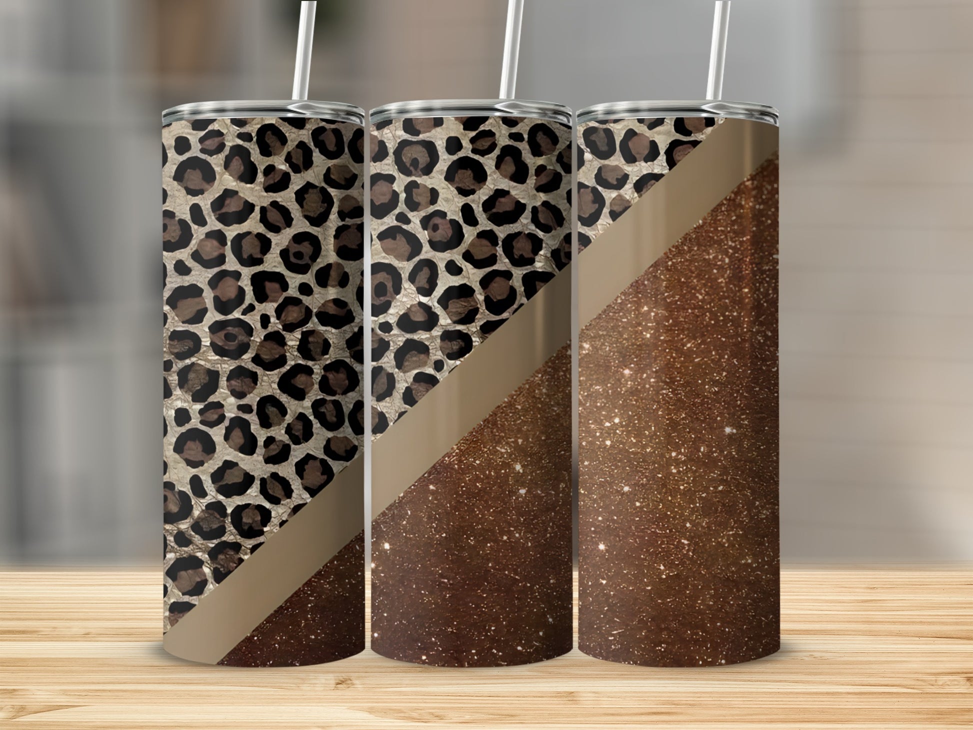 Three tumblers with leopard print and glitter designs on a wooden surface.