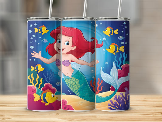 Ariel the mermaid swims with fish and coral on a blue background.