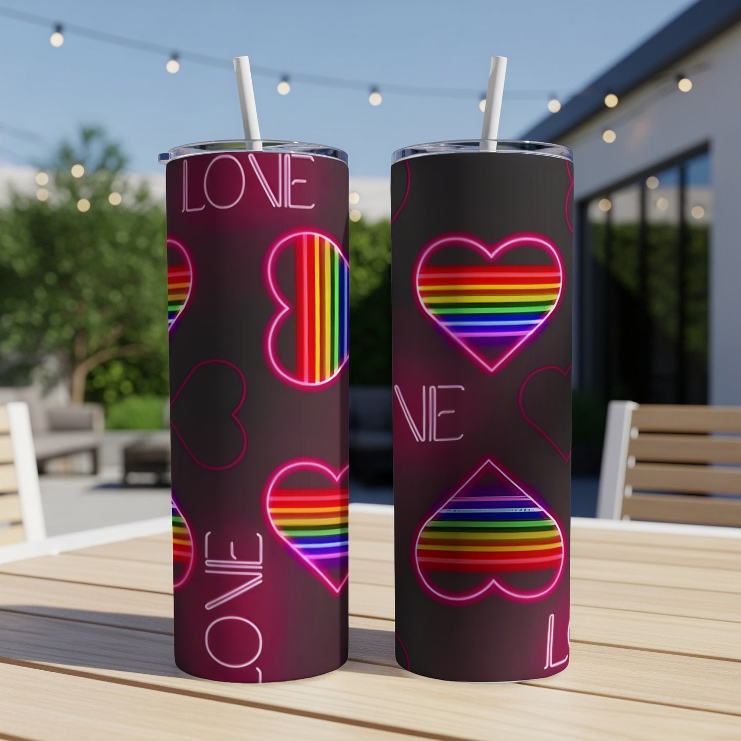 Two tumblers with rainbow hearts and "LOVE" text on a patio table.
