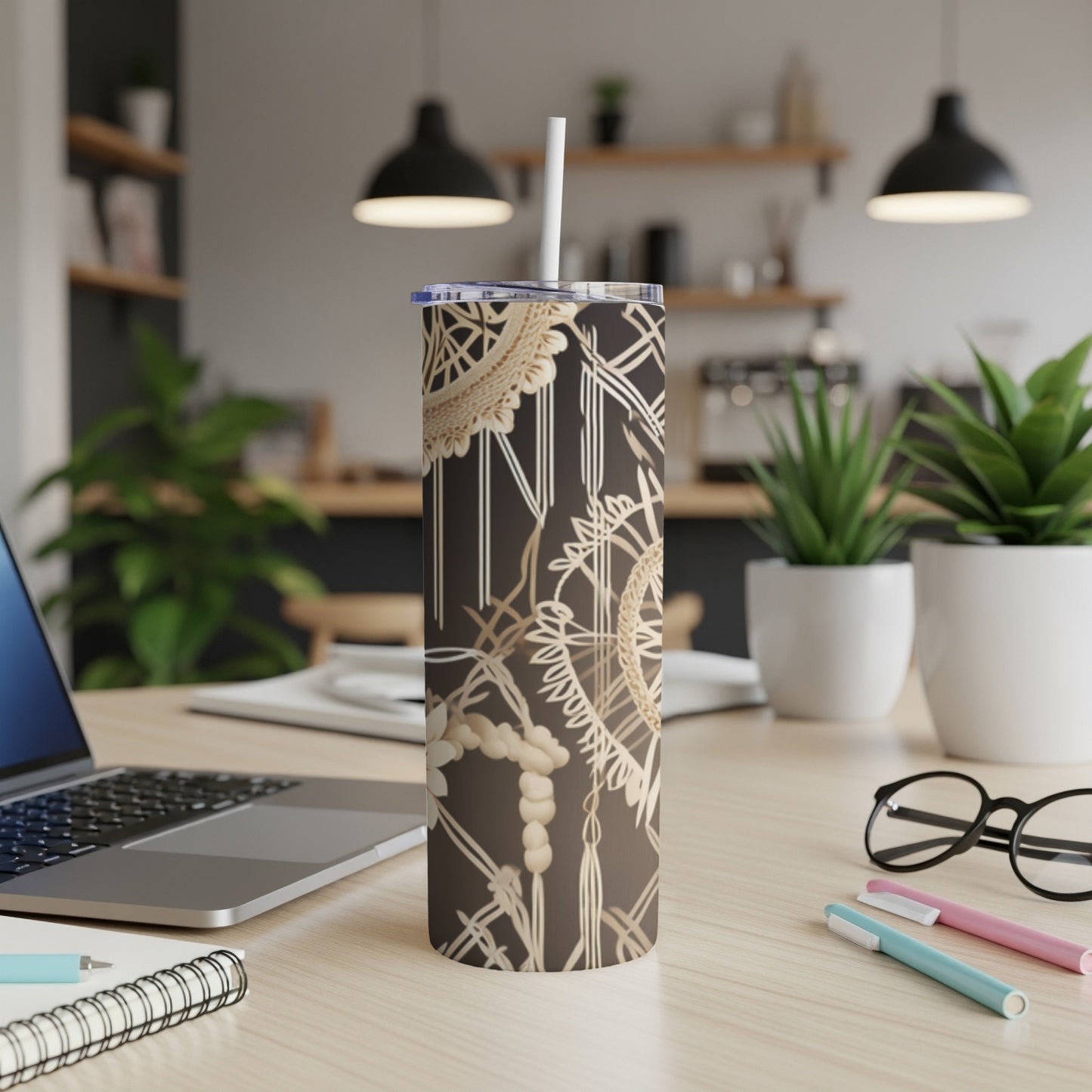 Brown tumbler with gold geometric pattern and straw on a desk.