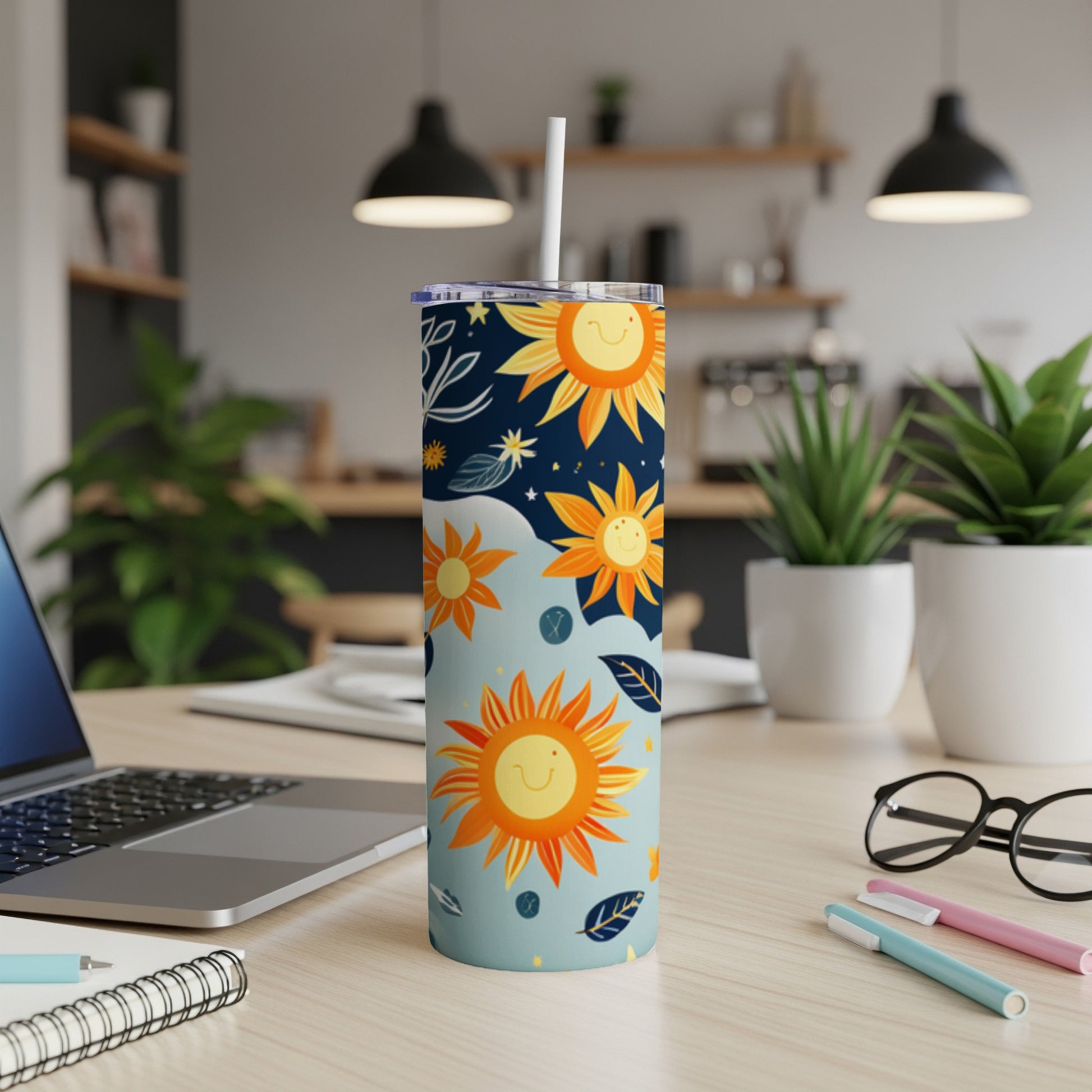 Tall blue tumbler with sun and star pattern, straw inserted.