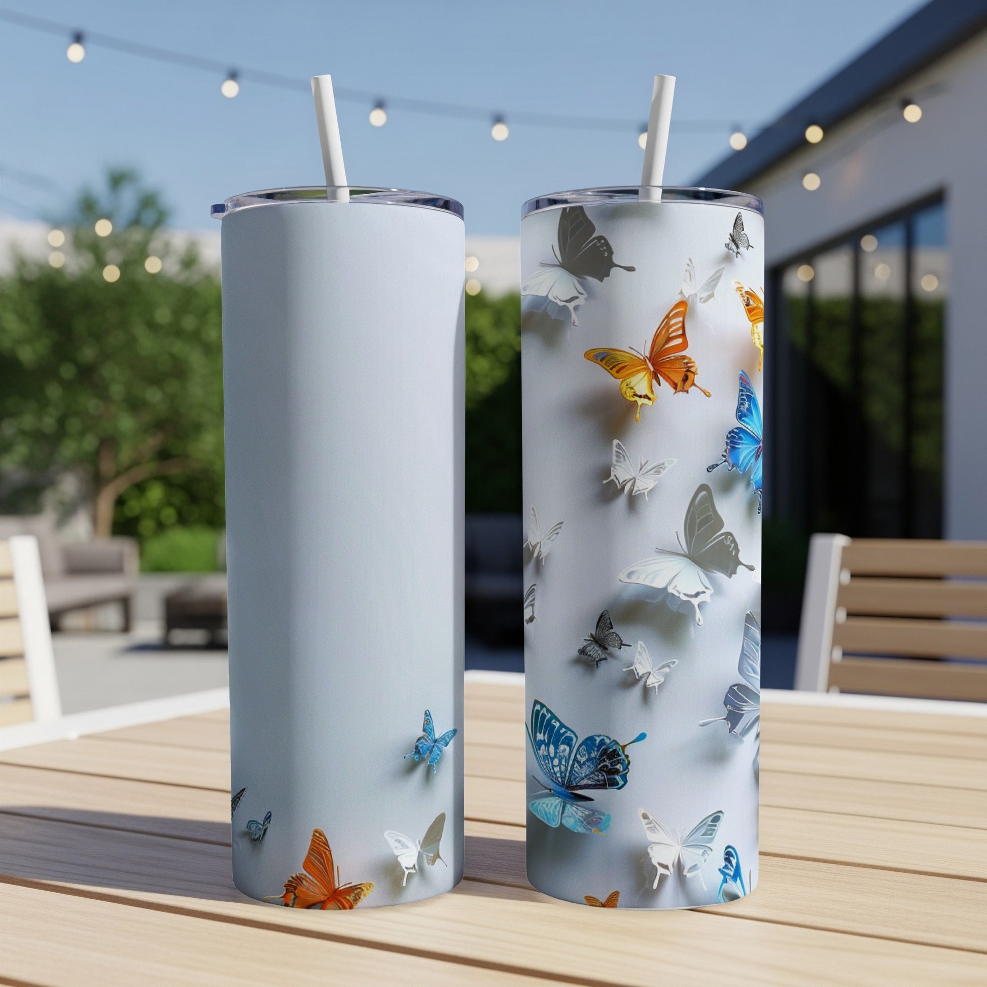 Two skinny tumblers with colorful butterflies, one light blue, one white.