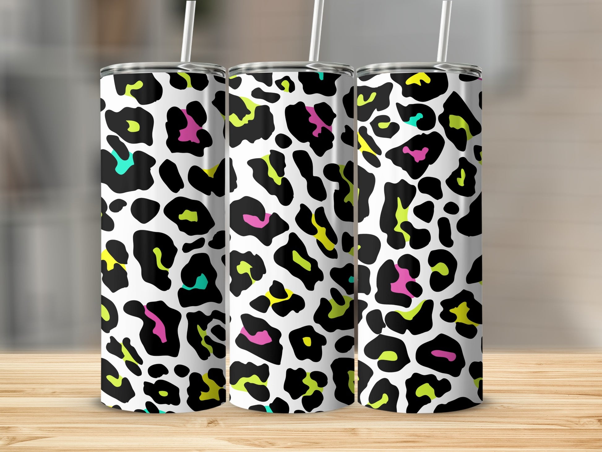 Three tumblers with a white background and brightly colored leopard print pattern.