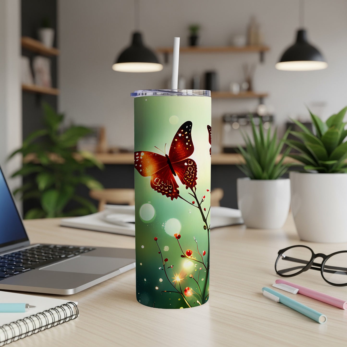 Tumbler with orange butterfly illustration on a speckled green background.