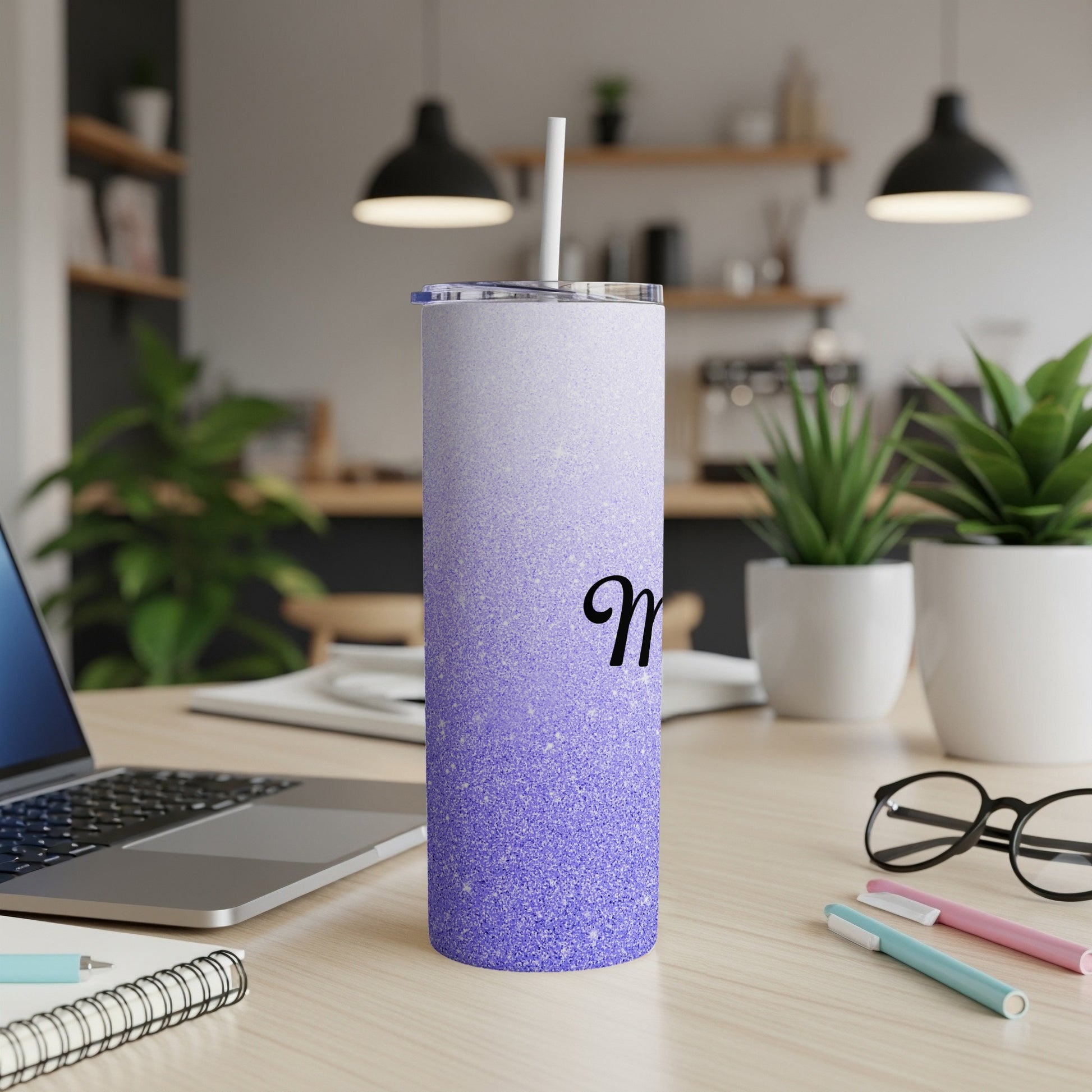 Purple glitter tumbler with white straw and a black "M" initial.