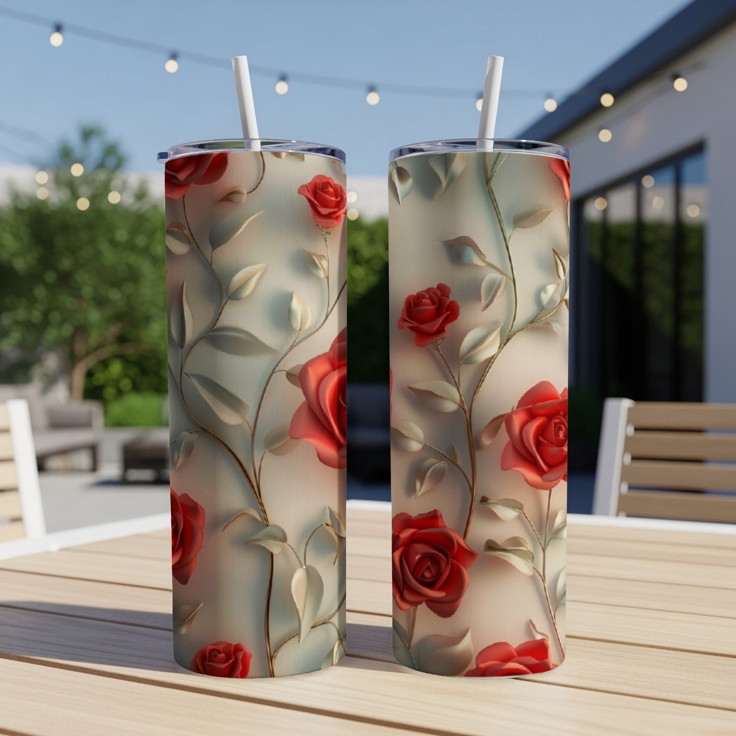 Two tumblers with a raised red rose floral design on a patio table.