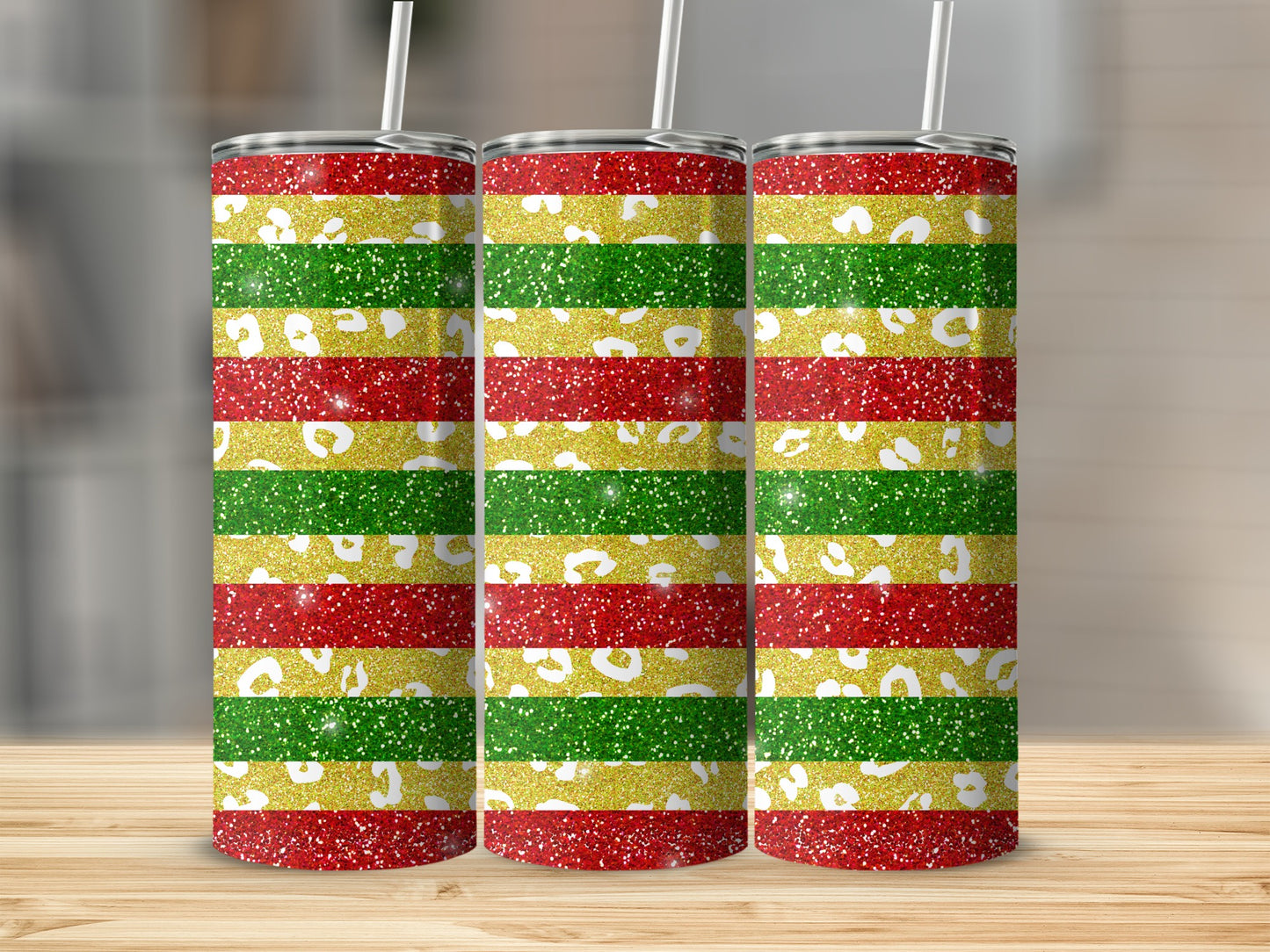 Three glitter-covered tumblers with red, gold, and green horizontal stripes.