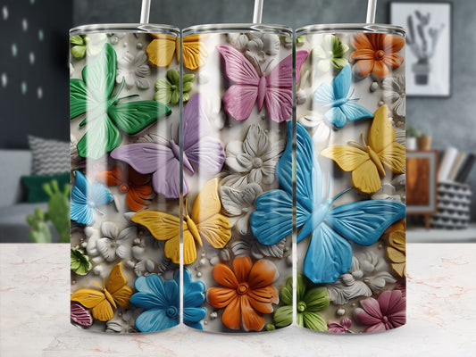 Three tumblers with colorful butterflies and floral designs.