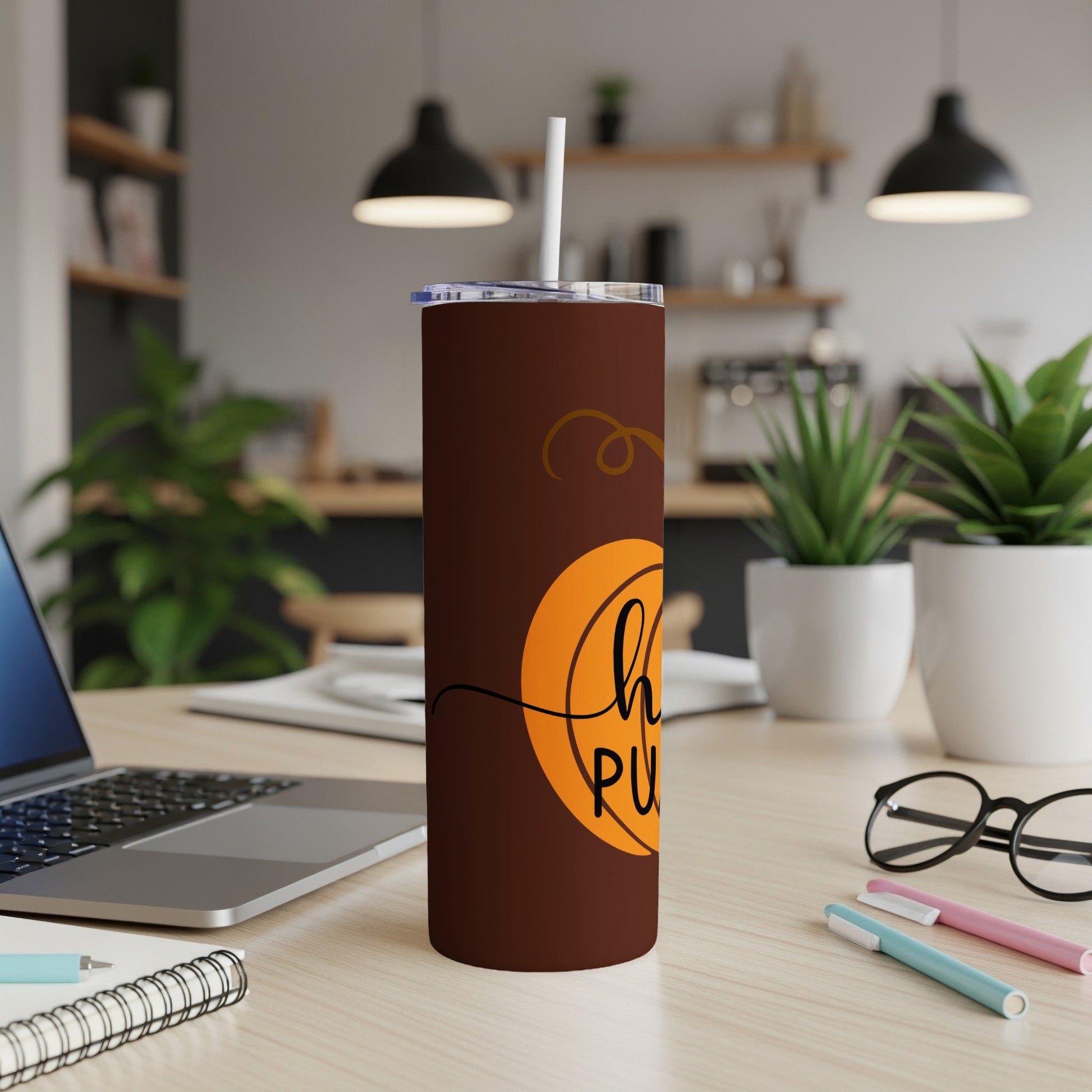 Brown tumbler with "Hello Pumpkin" text and straw on a desk.