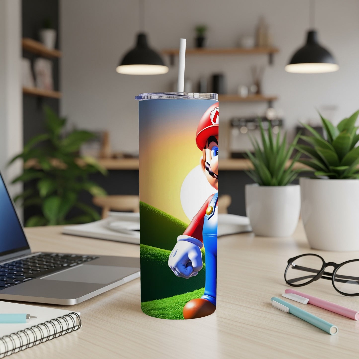 Mario character on a blue tumbler with straw, on a desk with laptop.