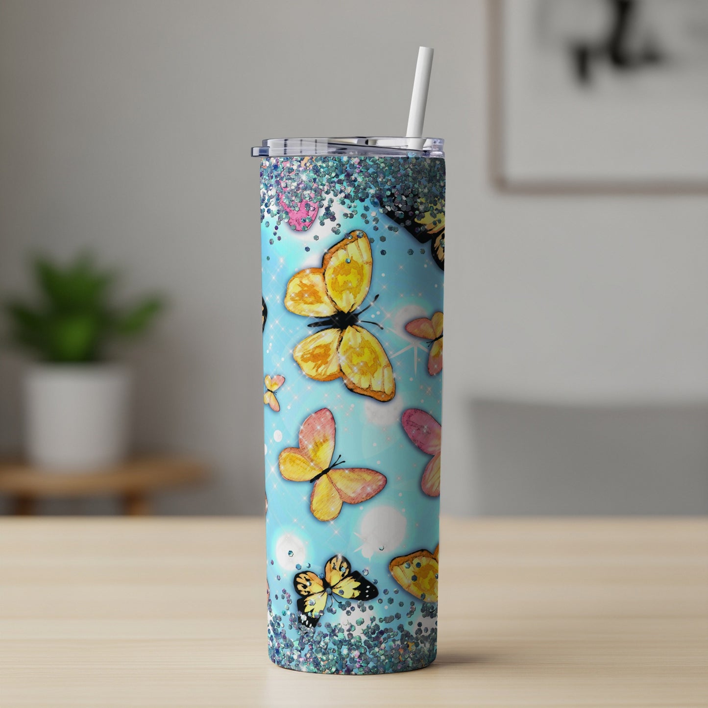 Blue tumbler with colorful butterflies and glitter, includes straw.