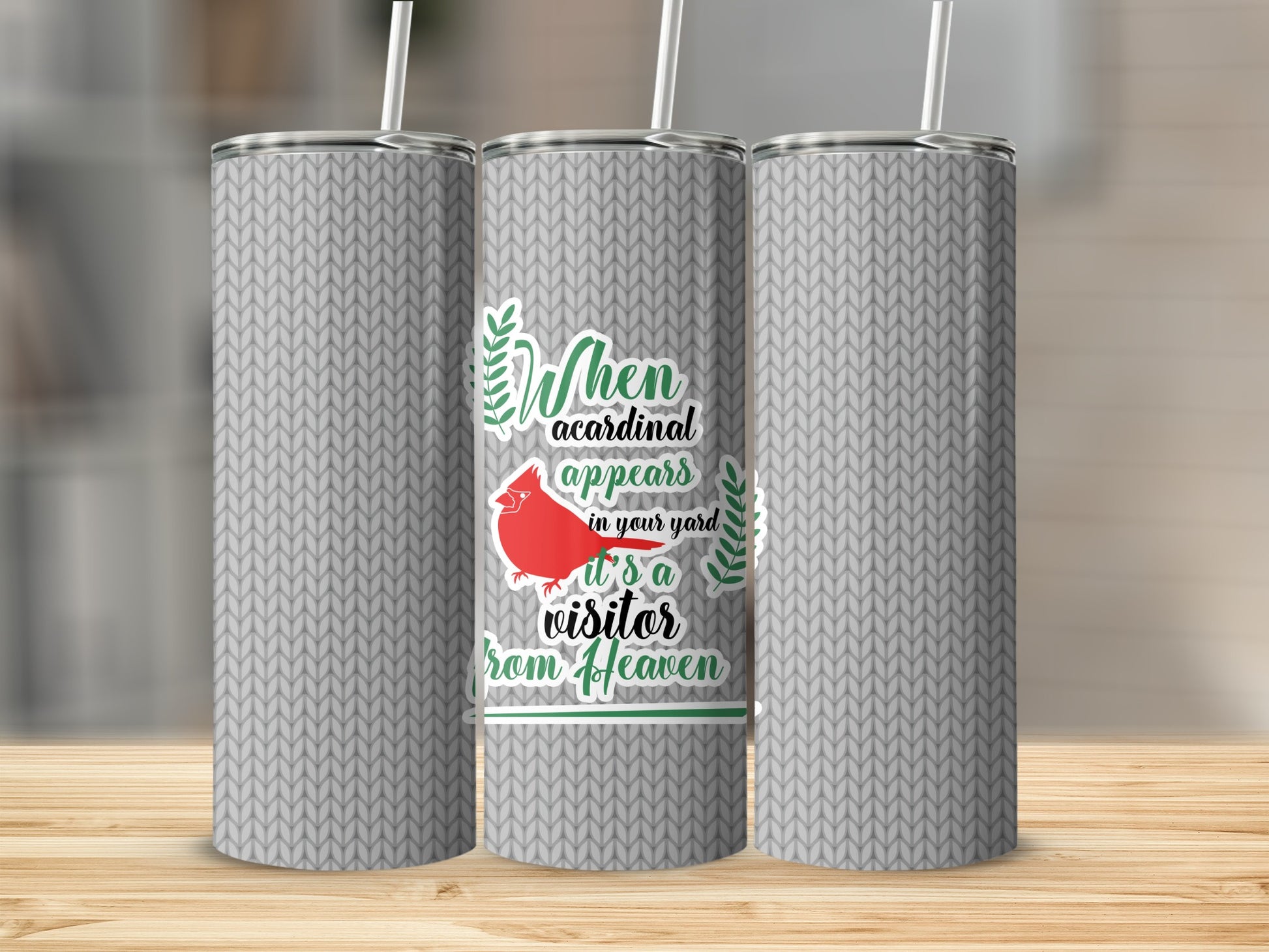 Cardinal and text design on a grey knit patterned tumbler.