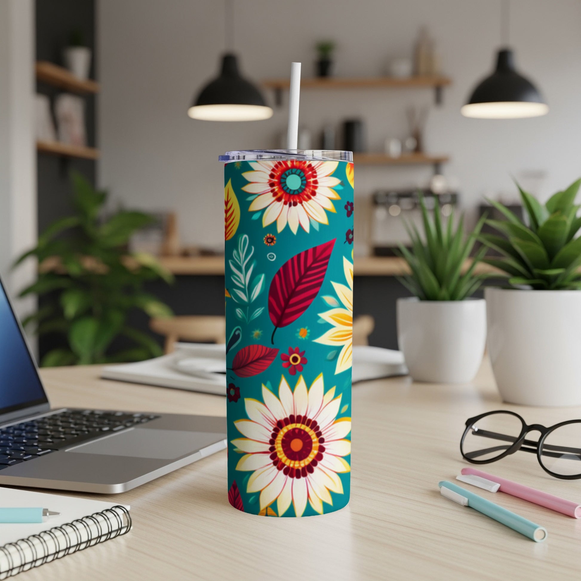 Tumbler with a vibrant floral and leaf pattern on a teal background.