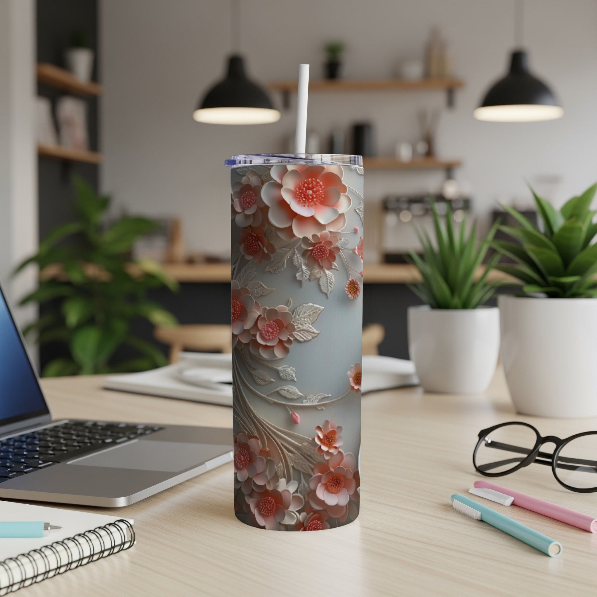 Floral patterned tumbler with white straw on a desk.