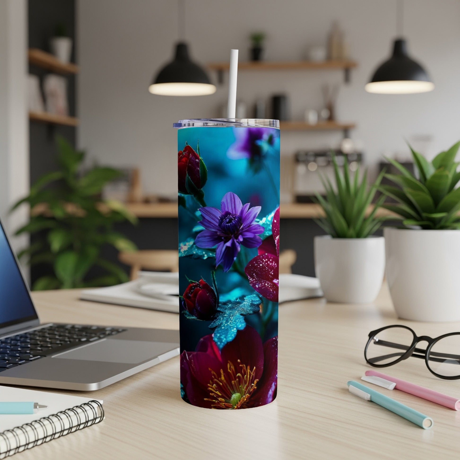 Tumbler with vibrant purple and red floral design, seen on a desk.