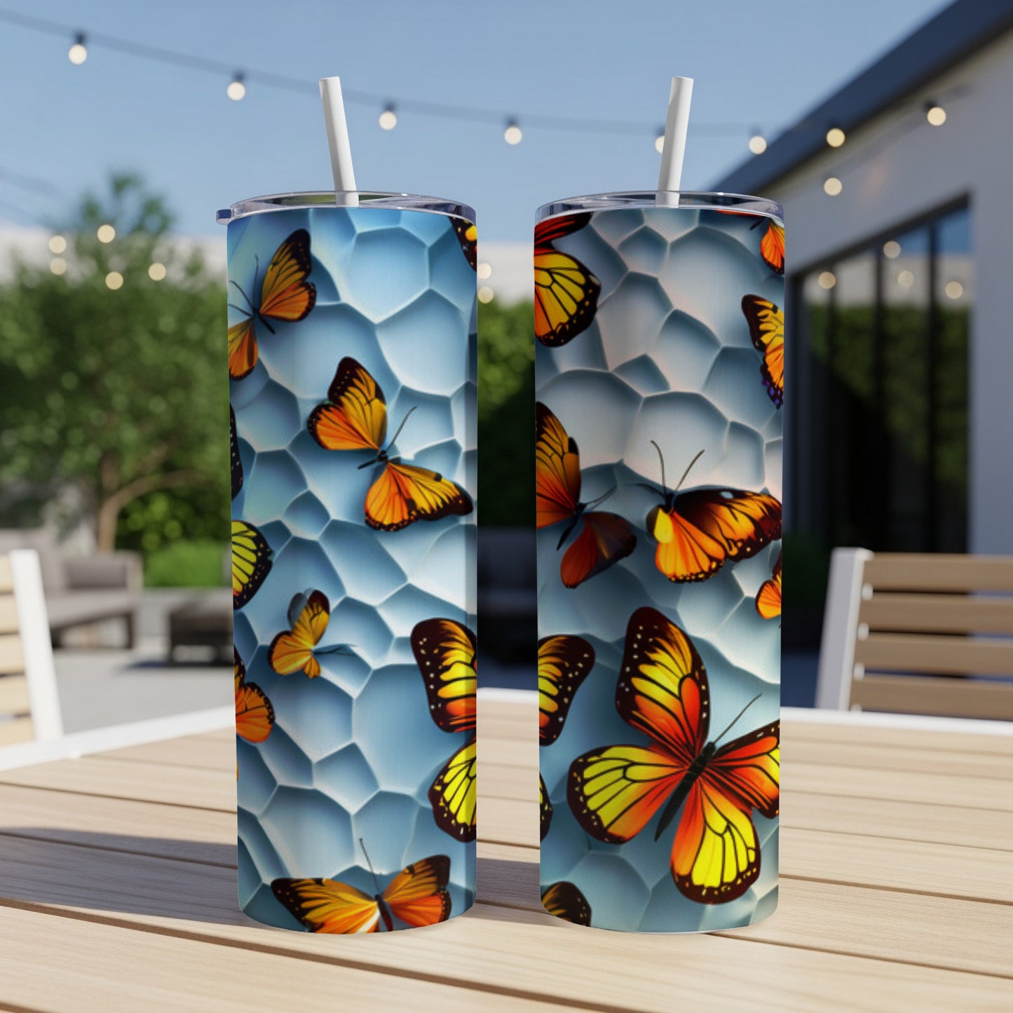 Two tall tumblers with orange and yellow butterflies on a textured blue background.