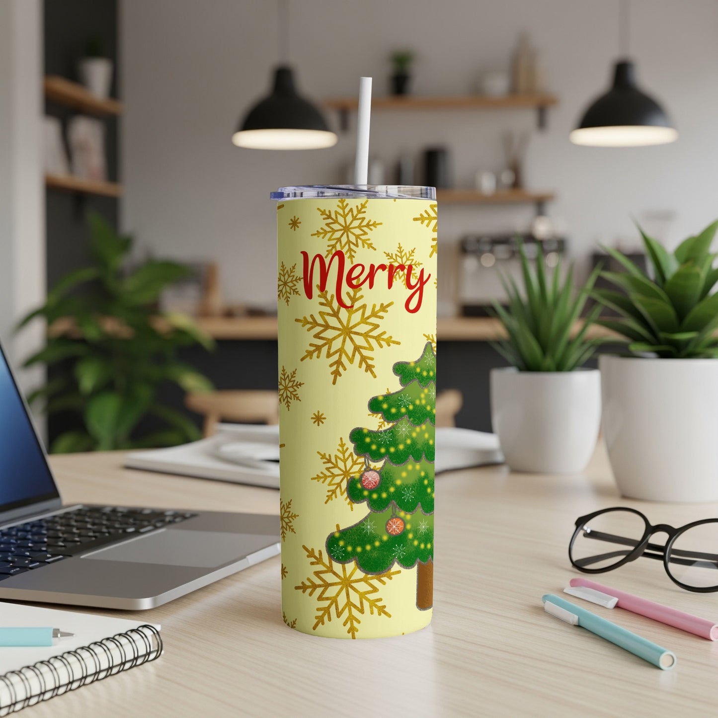 Yellow tumbler with a Christmas tree and snowflakes, says "Merry".