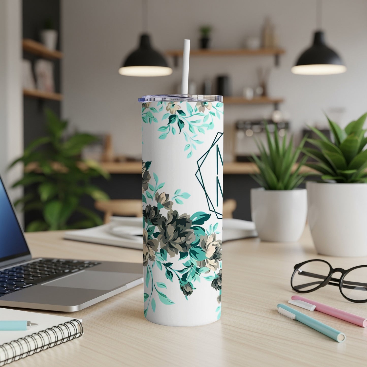 White tumbler with teal floral pattern and green monogram "A".