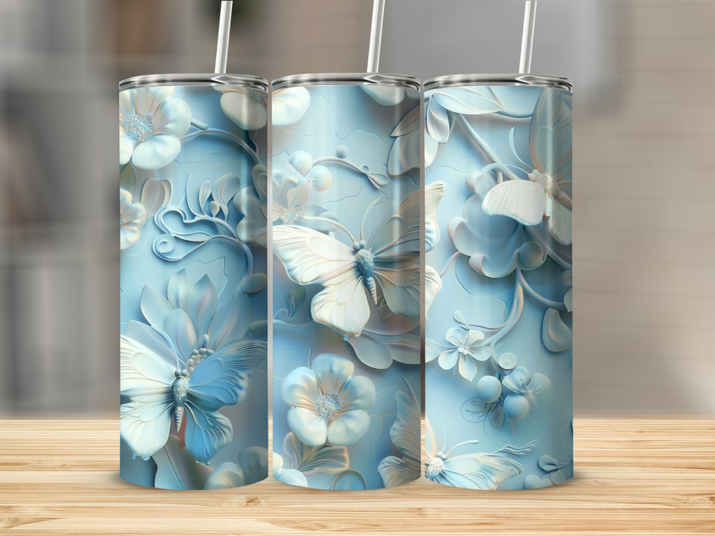 Three pale blue tumblers with intricate floral and butterfly embossing.