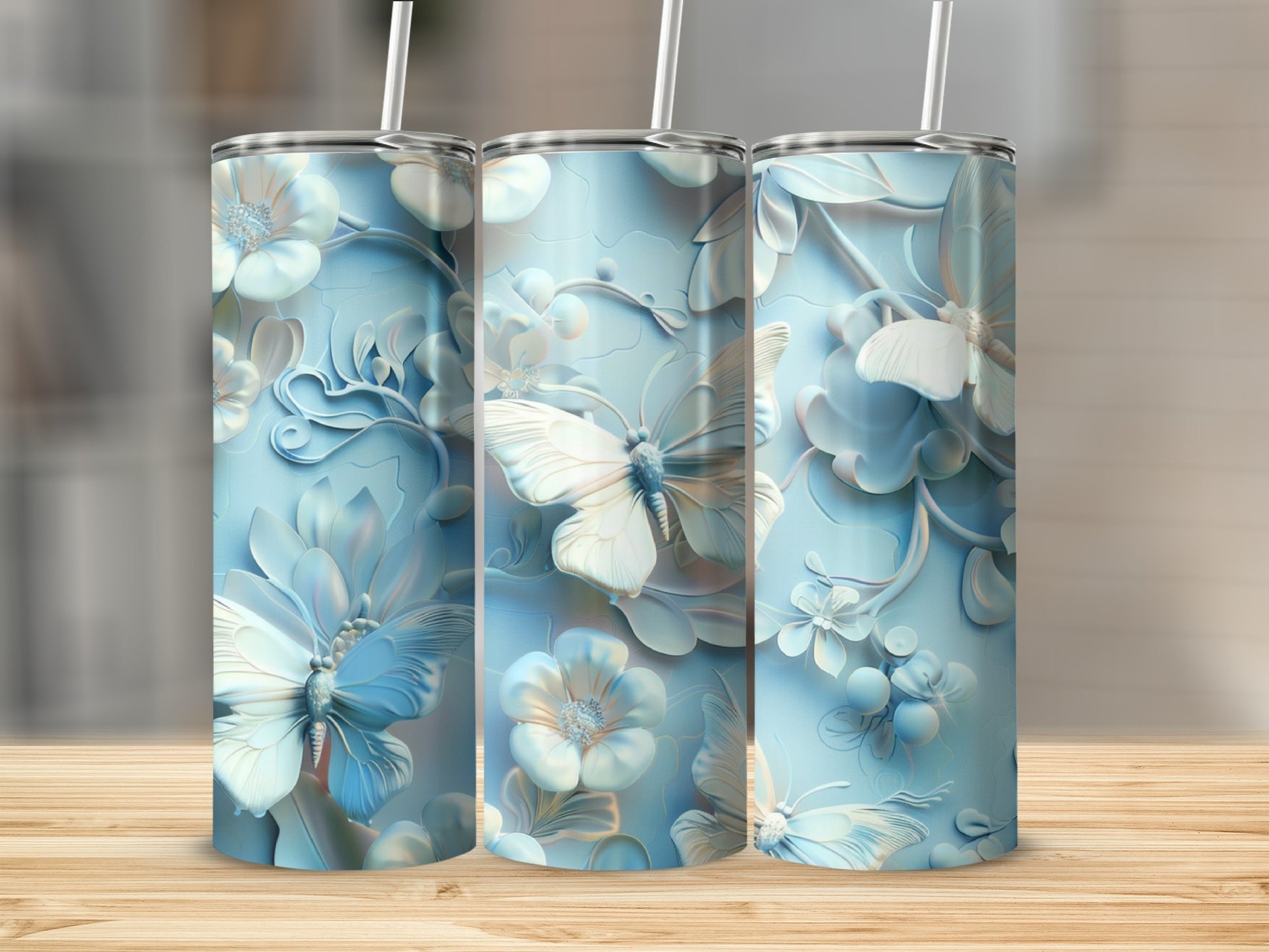 Three pale blue tumblers with intricate floral and butterfly embossing.