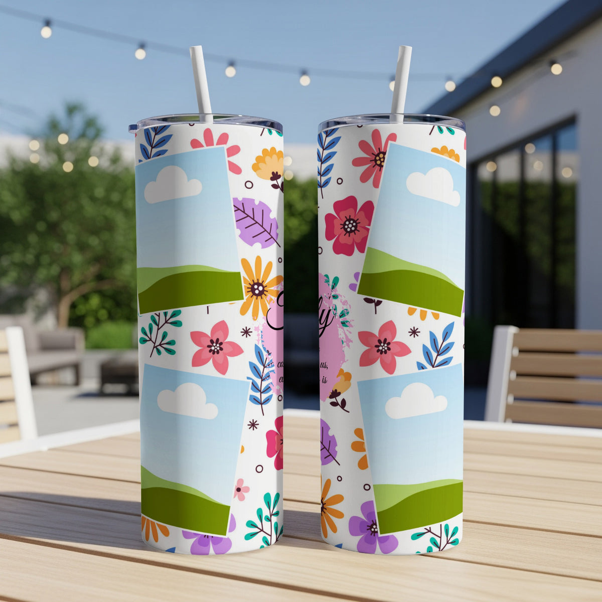 Two tumblers with a floral design and blank photo frames are on a wooden table.