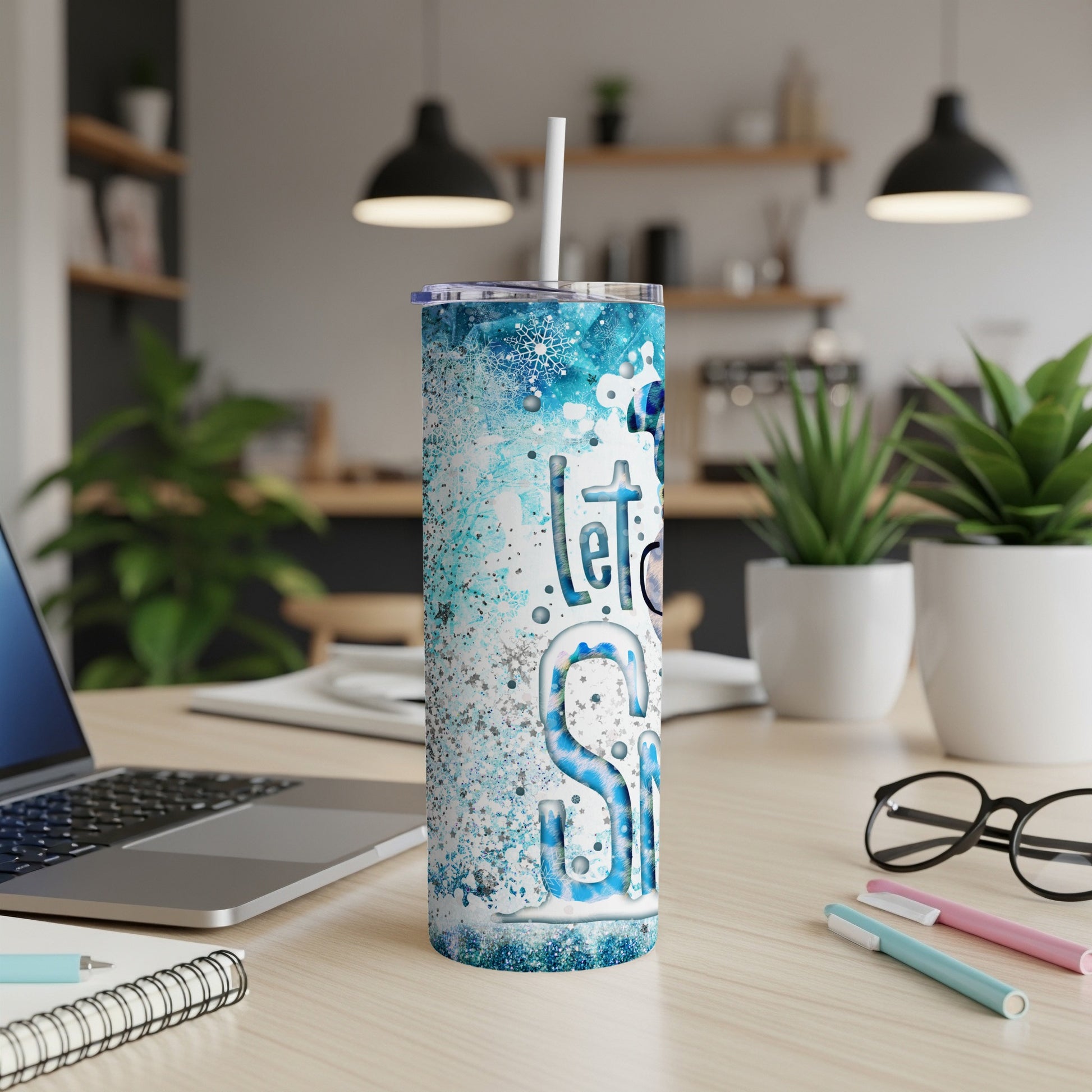 Tall skinny tumbler with snowflake design and "Let it Snow" text.