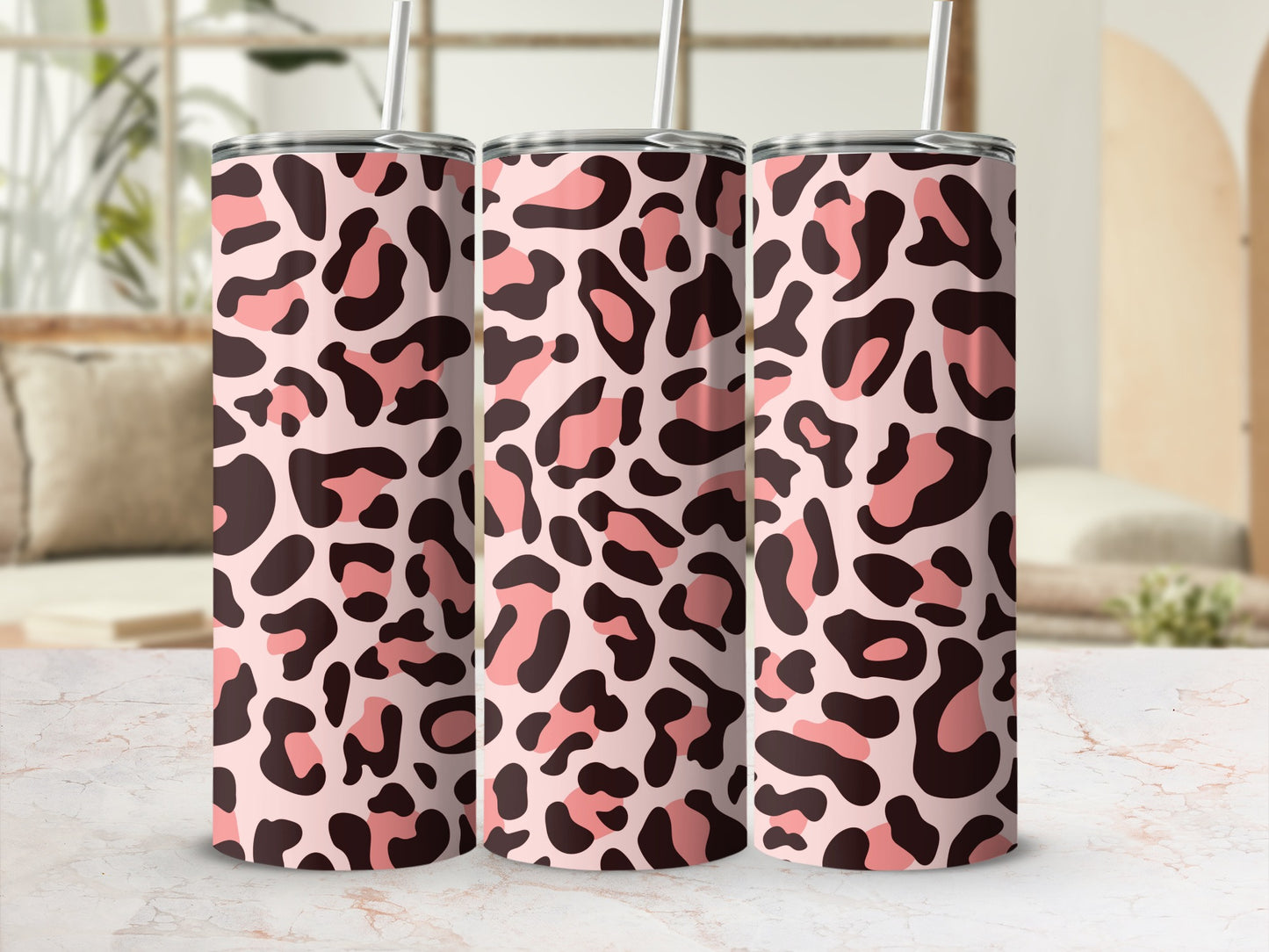 Three tumblers with pink and brown leopard print and silver straws.