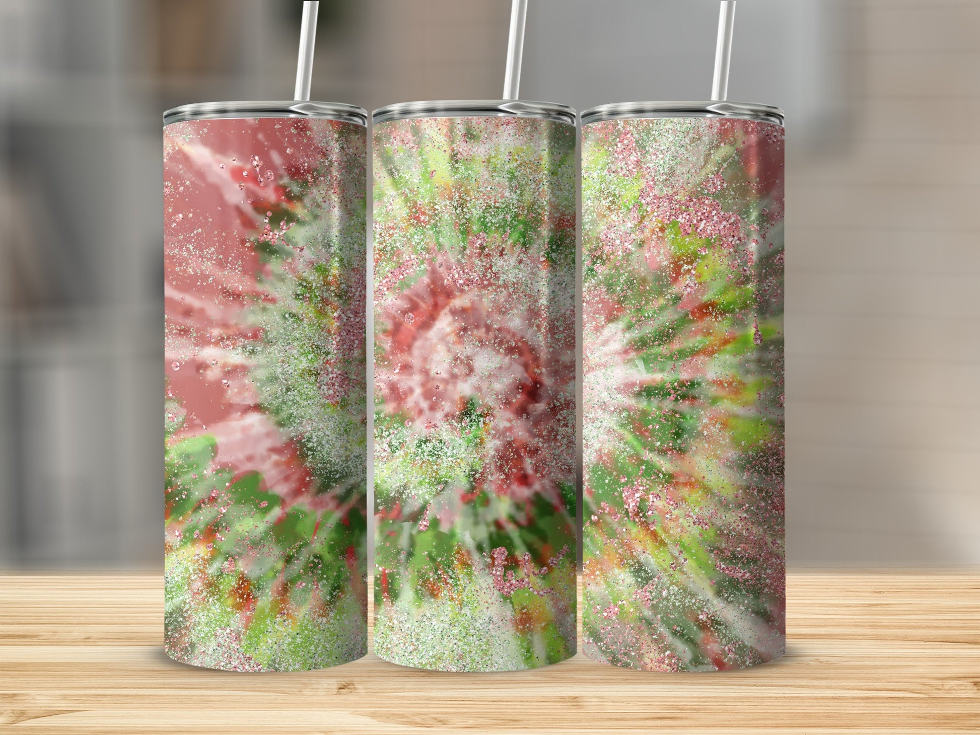 Three tumblers with a pink and green tie-dye glitter design and white straws.