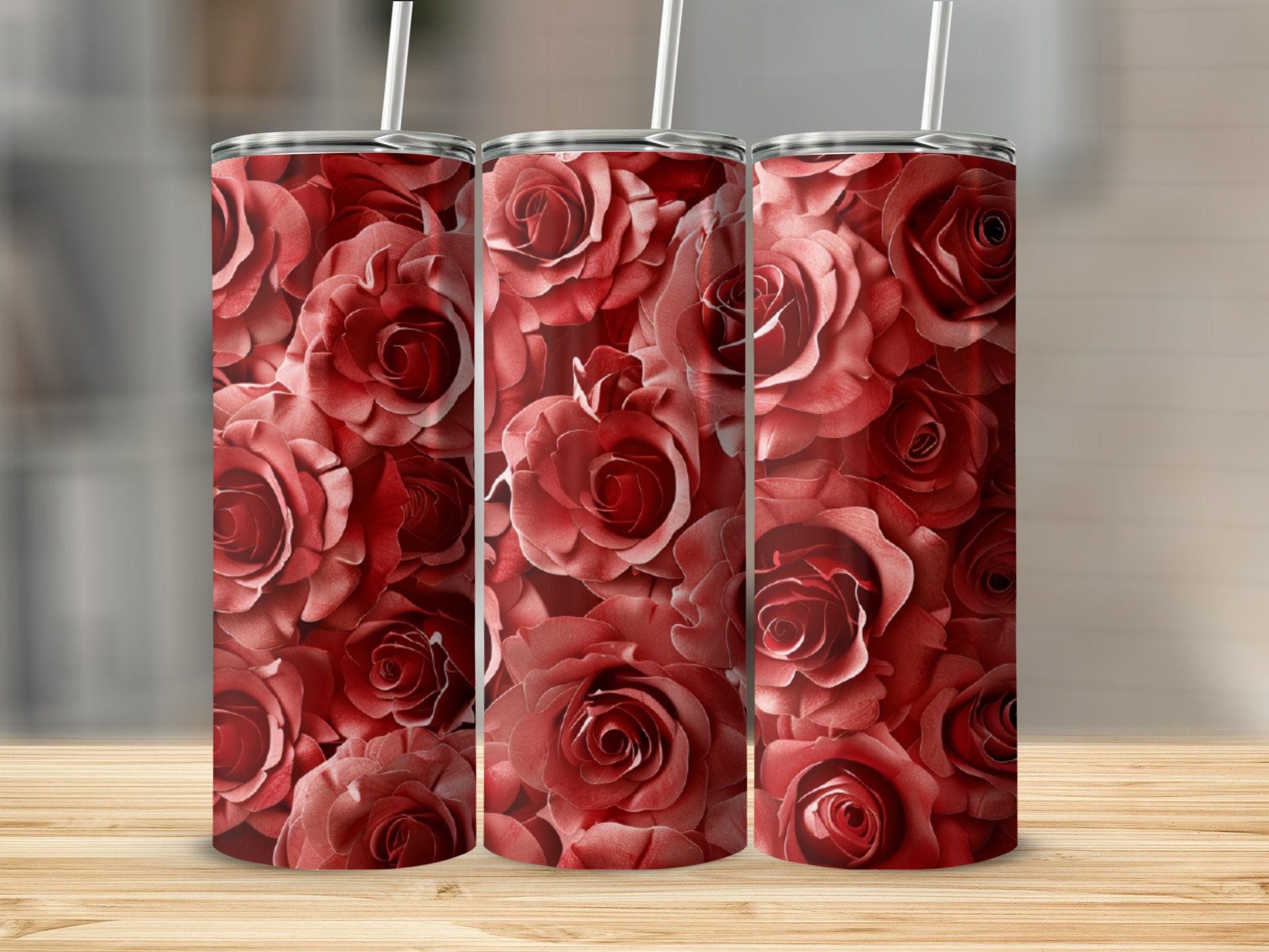 Three tumblers with a deep red rose pattern on a wooden surface.