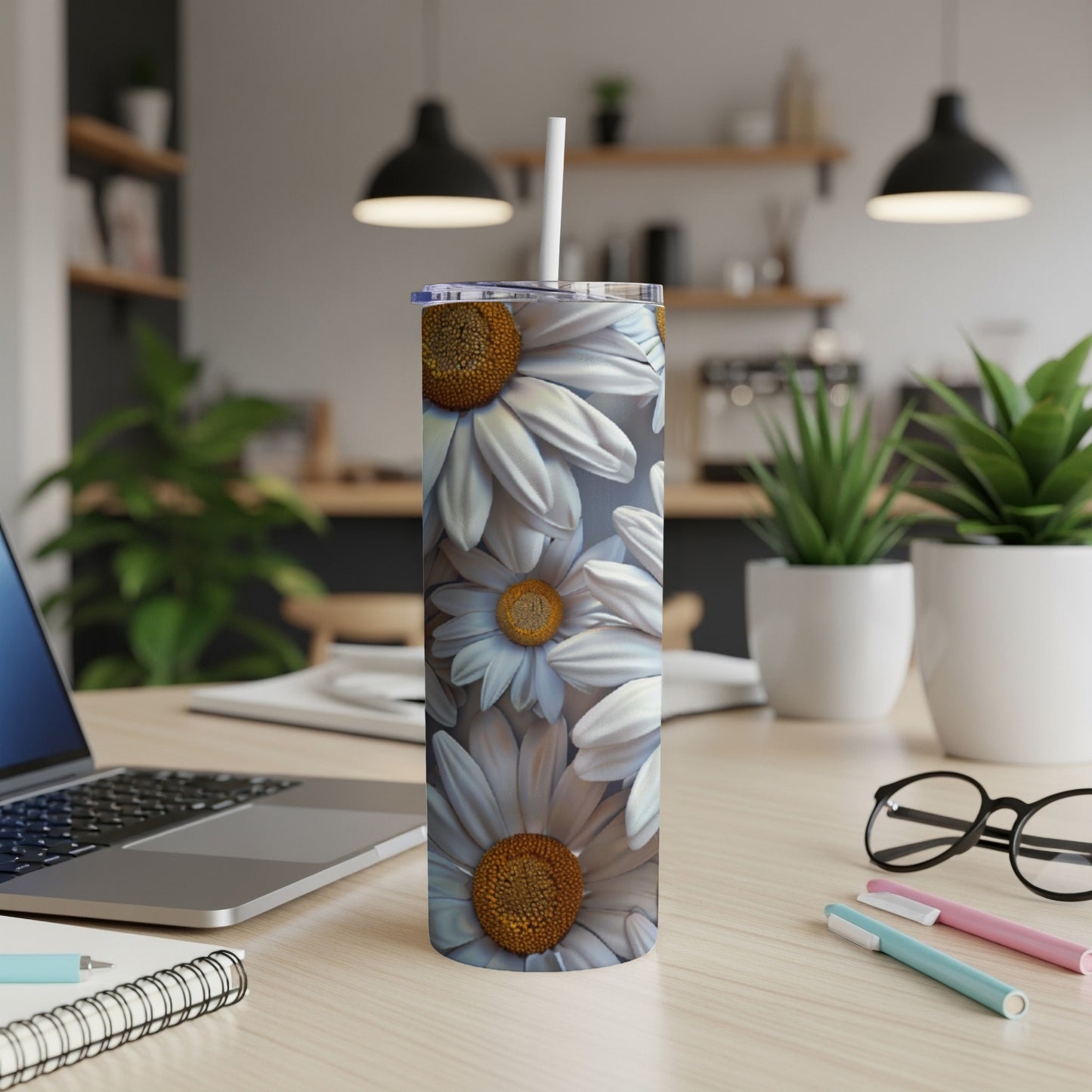 White daisy flowers on a tall, insulated tumbler with a white straw.