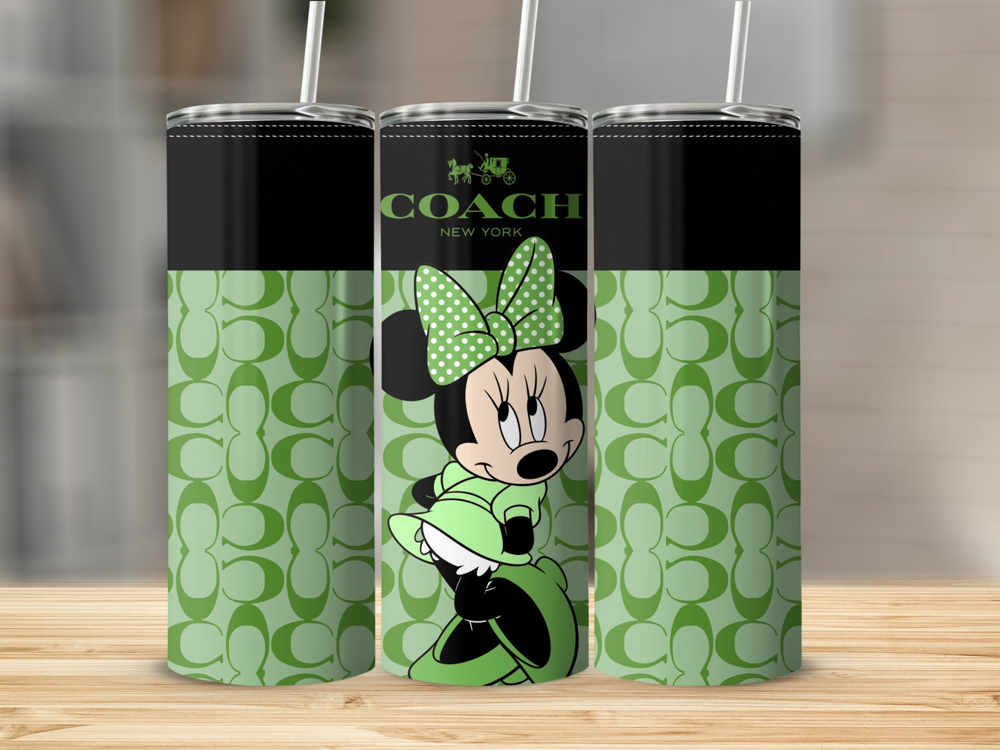 Three tumblers with Coach logo and Minnie Mouse design on a light green background.