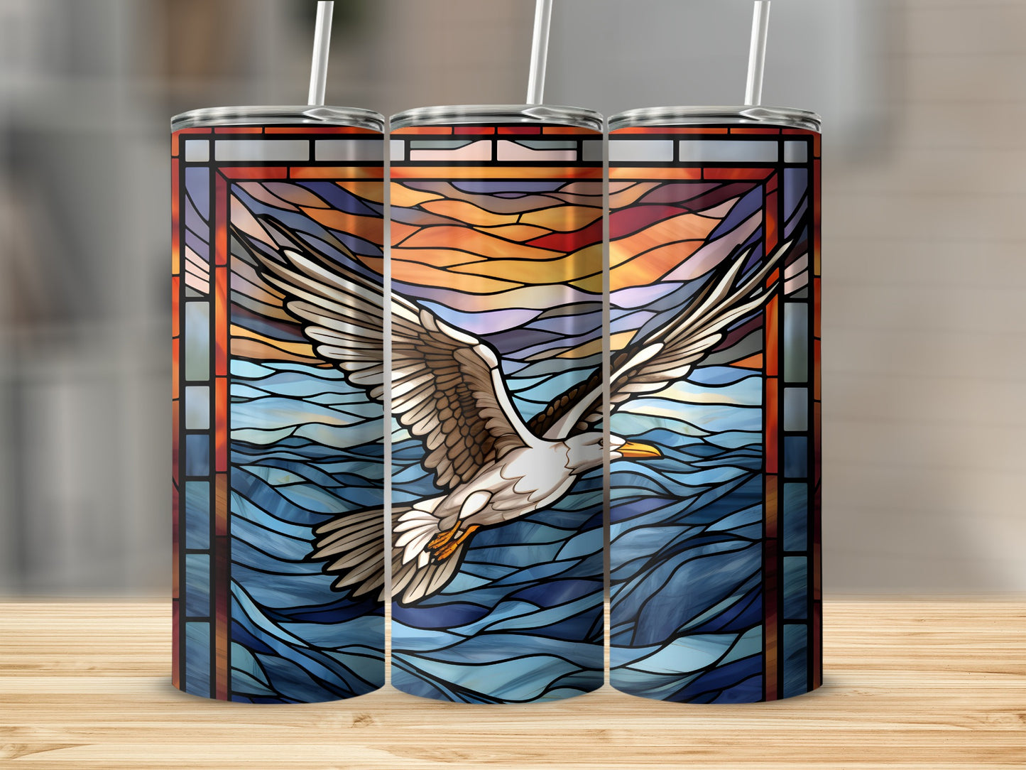 Stained glass tumbler with a seagull flying over waves at sunset.