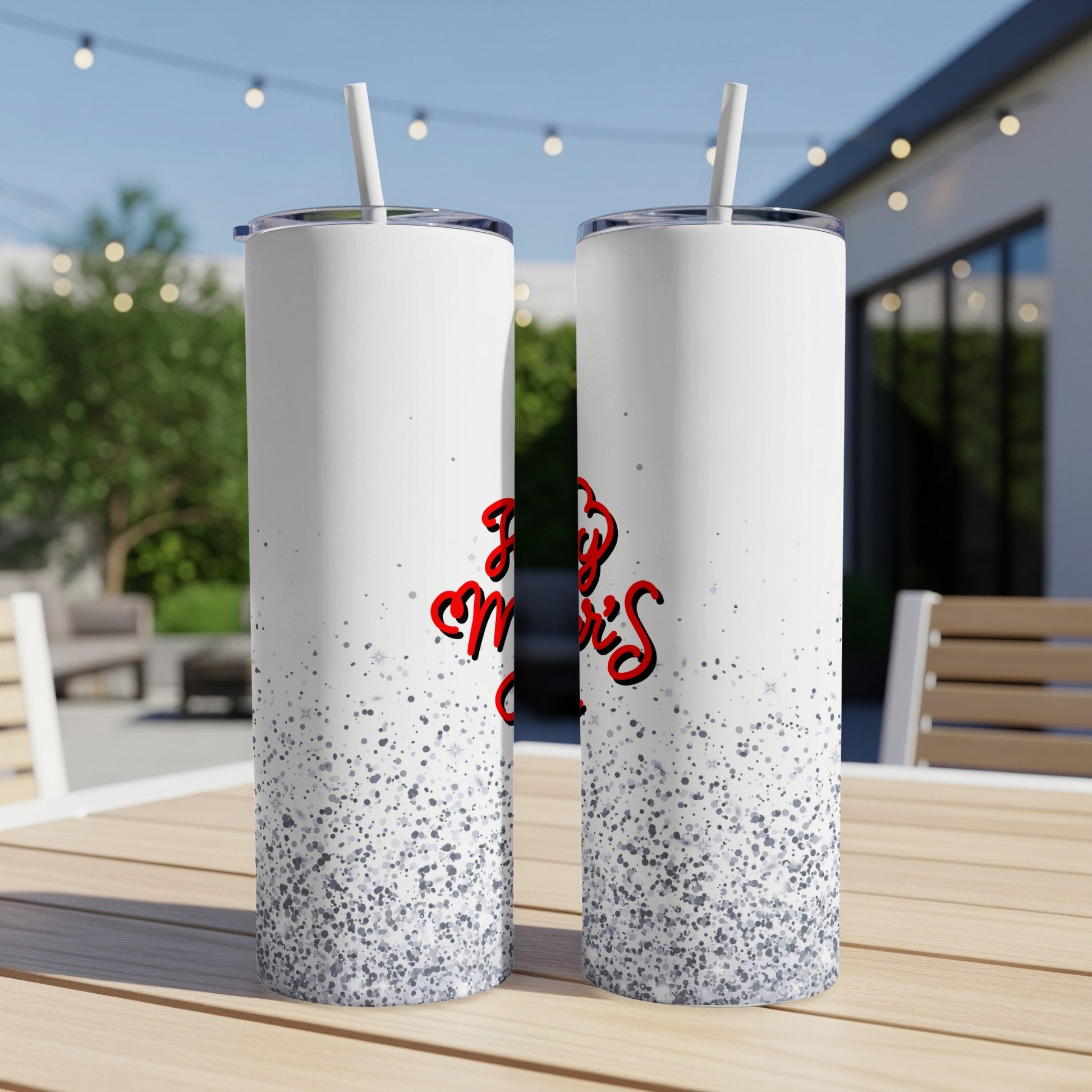 Two white tumblers with a glittery bottom and red script text that reads "Merry Christmas".