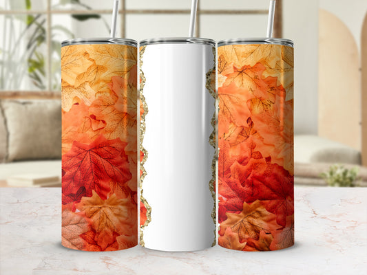 White tumbler with fall leaves and glitter edge on marble surface.